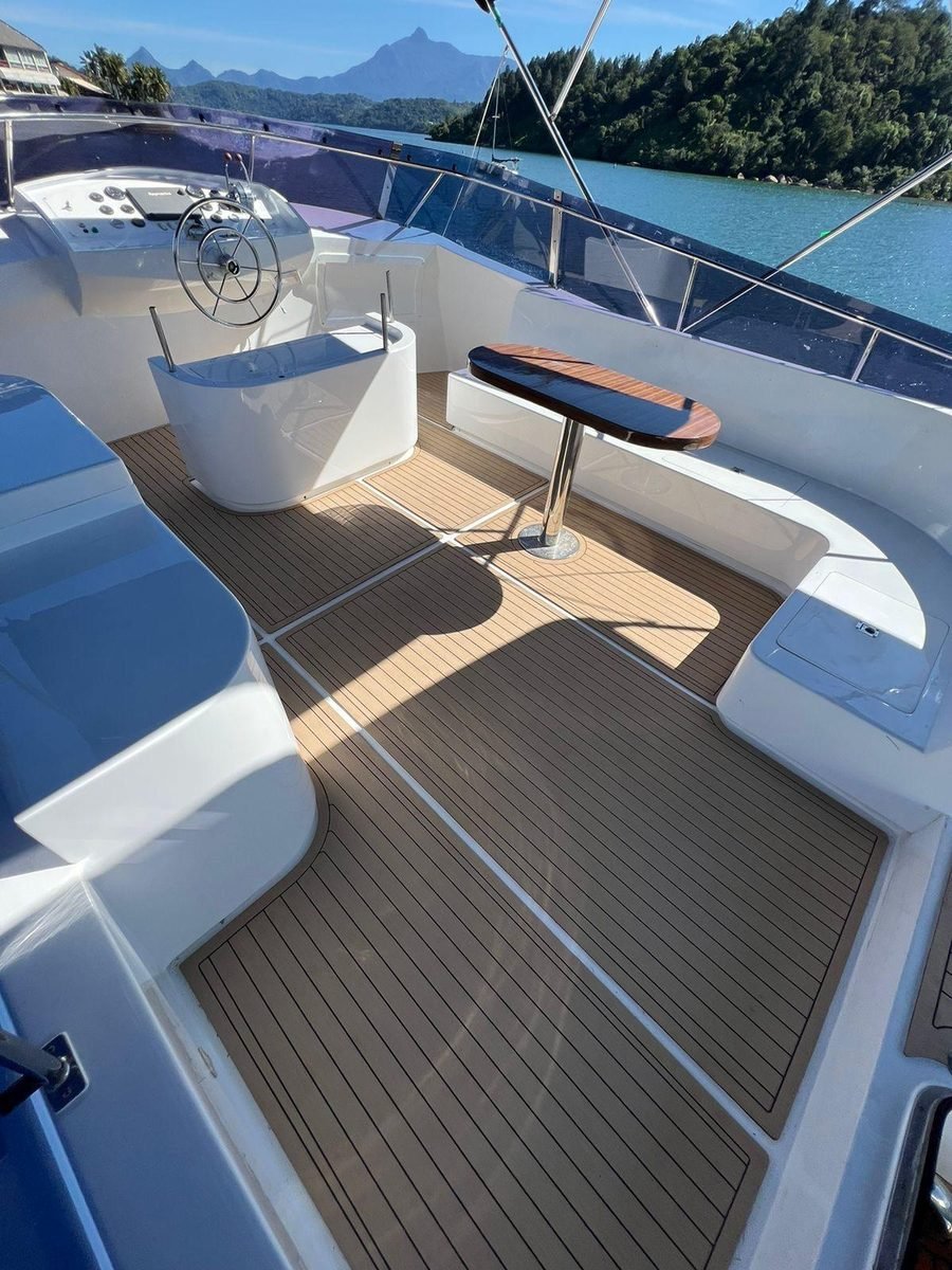 Flybridge com Thermo Deck instalado, mesa de teca e marina ao fundo
